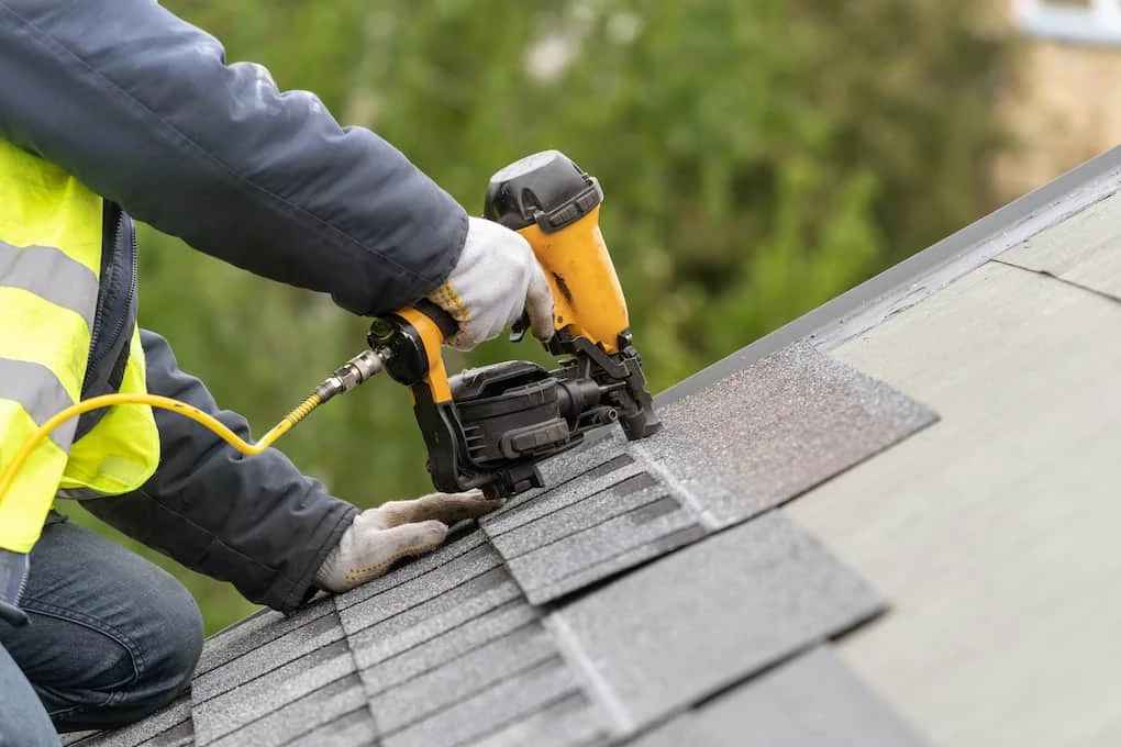 worker installing one of the cheapest roofing materials asphalt