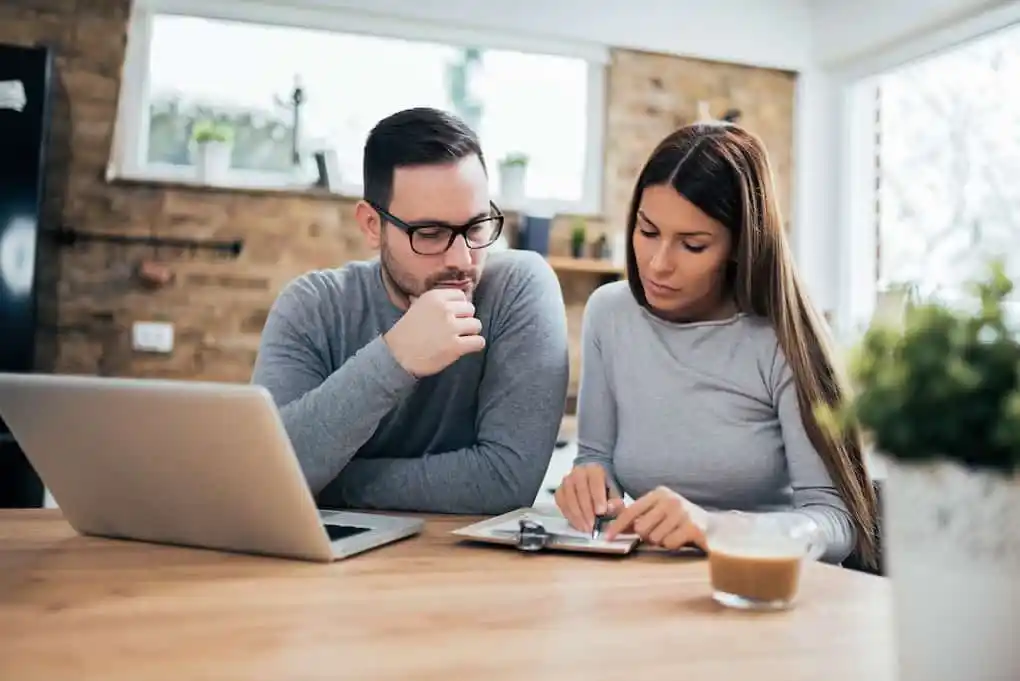 couple analyzing their insurance claim for roof replacement