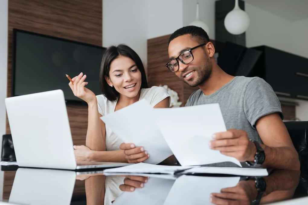 couple using laptop and analyzing roofing material costs