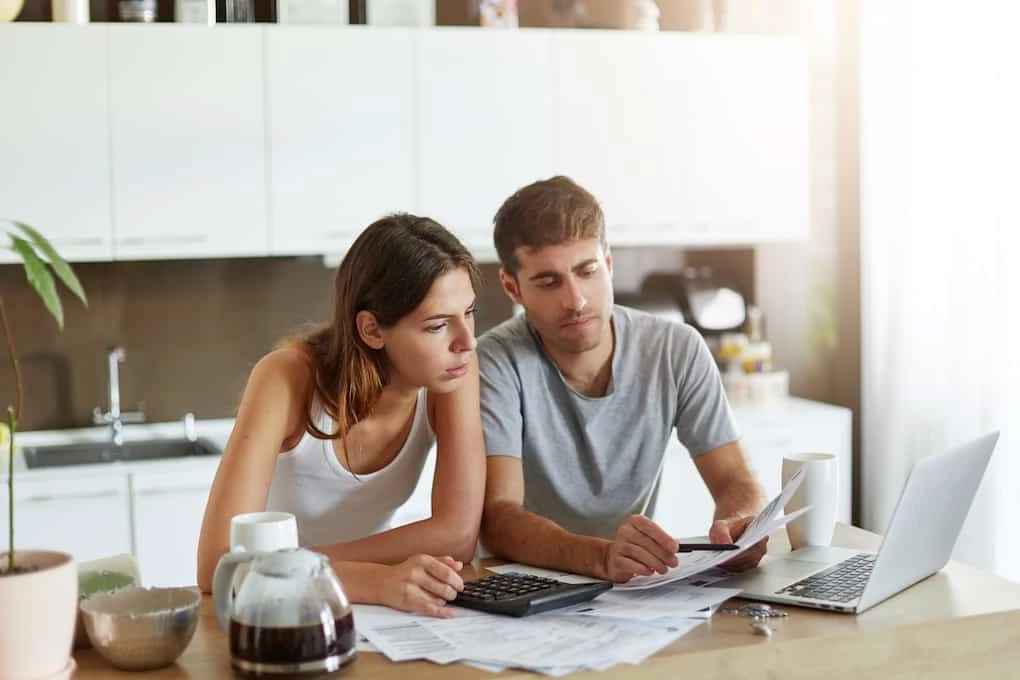 young couple going over unexpected costs after roof scams